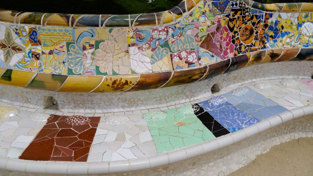 グエル公園のベンチを覆う、青・黄・白のトレンカディス(タイルモザイク)