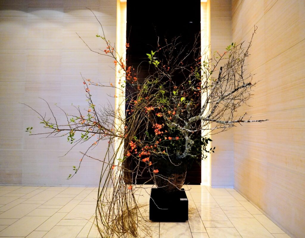 コンラッド東京ロビーの生け花。荒々しい枝ぶりと橙色の小花