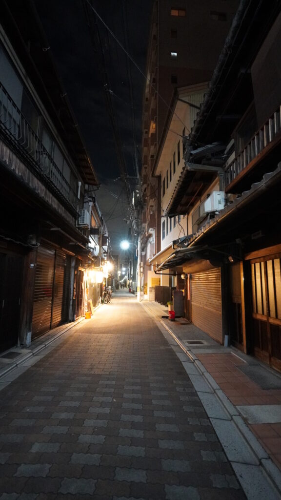 京都の夜の路地。灯りの点る町家が軒を連ねる