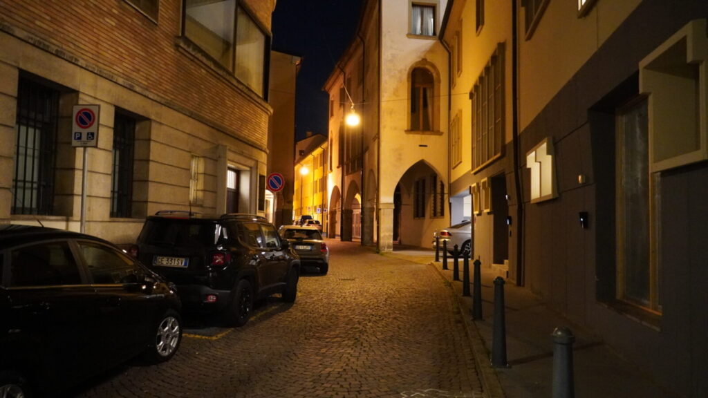 街灯がともるパドヴァの夜の路地。人通りの引いた石畳と、アーケードのやわらかな明かり